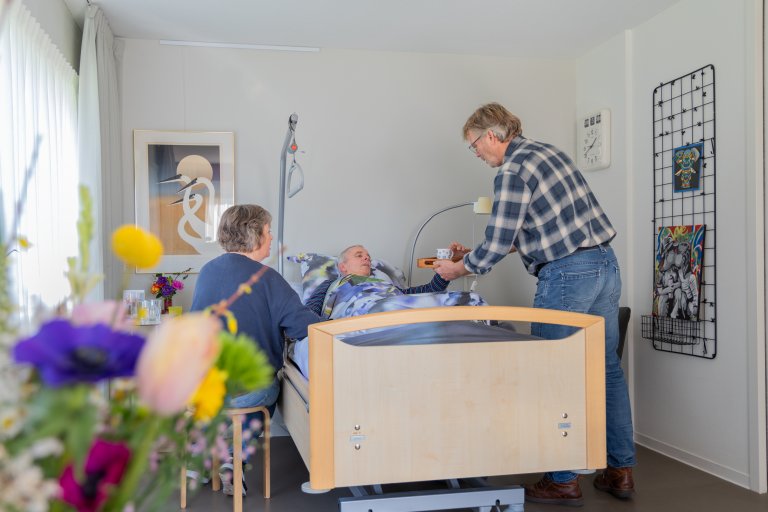 Twee mensen aan het bed van een gast